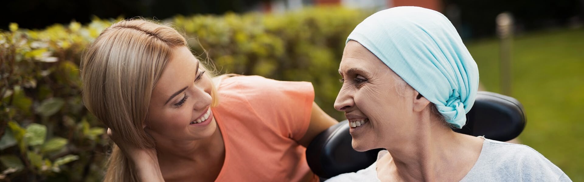 woman with head scarf smiling at a blonde woman next to her