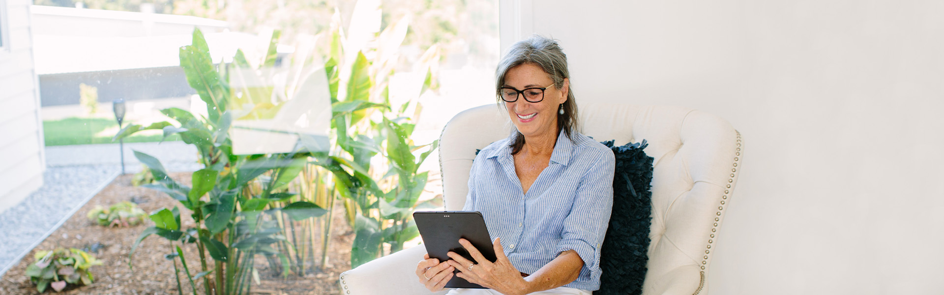 Client smiling at ipad speaking with clinician during telehealth appointment