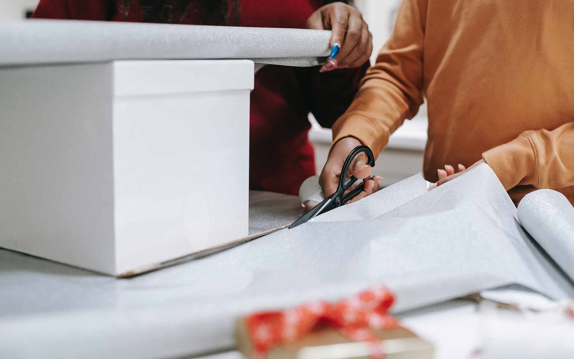 Two people wrapping presents planning an inclusive Christmas
