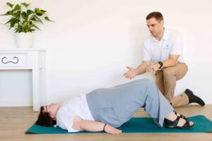 Physiotherapy session where client is on exercise mat undertaking exercise as supervised by a physiotherapist